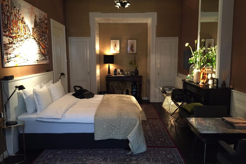 Spacious boutique guest room combining classic architectural details, contemporary artwork and refined furnishings at Villa Nicola, Amsterdam