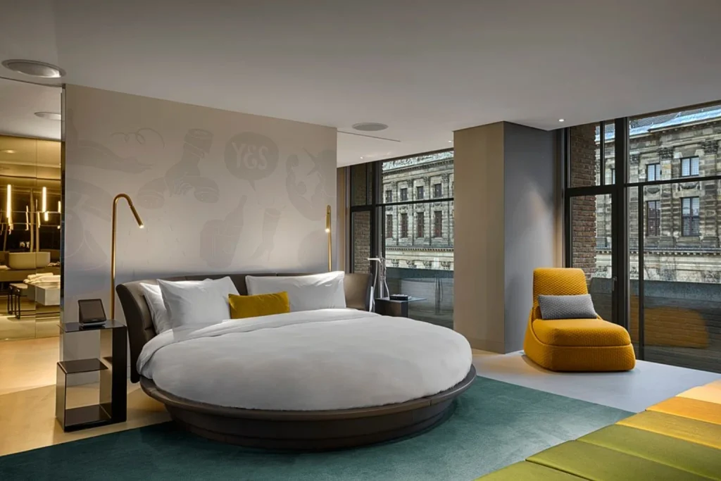 Modern luxury hotel room with round bed, floor-to-ceiling windows and contemporary interior at W Amsterdam, Amsterdam, Netherlands